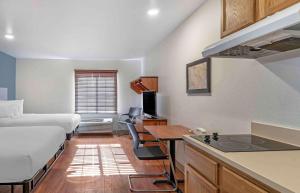 a small room with a bed and a desk and a kitchen at Extended Stay America Select Suites - Louisville - South 