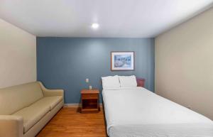 1 dormitorio con 1 cama grande y 1 sofá en Extended Stay America Select Suites - Lubbock - South en Lubbock