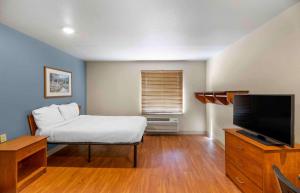 a bedroom with a bed and a flat screen tv at Extended Stay America Select Suites - Lubbock - South in Lubbock