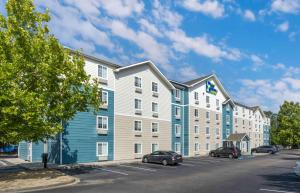 a large building with cars parked in a parking lot at Extended Stay America Select Suites - Charleston - North Charleston - I-526 in Charleston