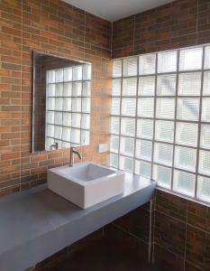 a bathroom with a white sink and windows at Chang Chang Hostel in Chiang Mai