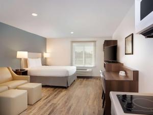 a hotel room with a bed and a couch at Extended Stay America Select Suites - Melbourne - West Melbourne in Melbourne