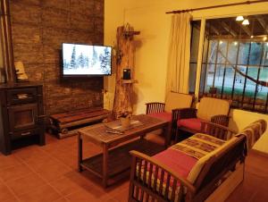 a living room with a table and a tv at La Posada de Buda in Malargüe