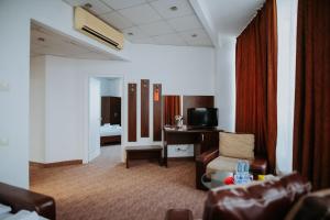 a living room with a couch and a chair and a desk at Hotel Select in Sibiu
