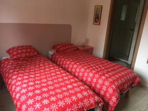 - une chambre avec 2 lits et une couette rouge dans l'établissement Gites au jardin, à Morsbronn-les-Bains 67 autres photos