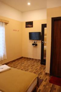 a bedroom with a bed and a flat screen tv at LAZY RETREAT in Vagamon