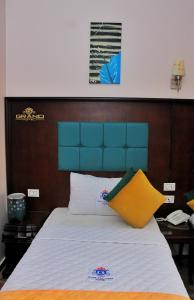 a bedroom with a bed with a blue head board at Grand Hotel Ras Elbar in Ras El Bar