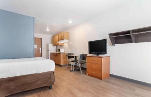 a bedroom with a bed and a kitchen with a television at Extended Stay America Select Suites - Montgomery in Montgomery