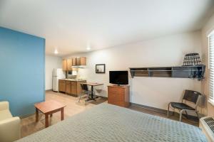a bedroom with a bed and a desk and a kitchen at Extended Stay America Select Suites - Ocala in Ocala