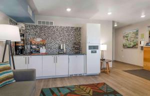 a living room with a kitchen with white cabinets at Extended Stay America Suites - Nashua - Merrimack in Merrimack