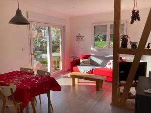 un salon avec un canapé rouge et une table dans l'établissement Gites au jardin, à Morsbronn-les-Bains