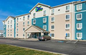 a large building with a car parked in front of it at Extended Stay America Select Suites - Cleveland - Avon in Avon