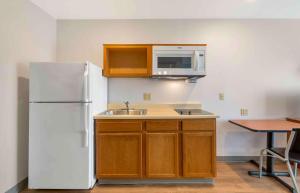 a kitchen with a white refrigerator and a sink at Extended Stay America Select Suites - Cleveland - Avon in Avon