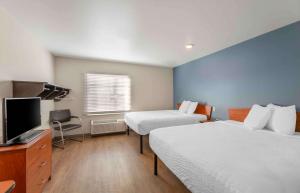 a hotel room with two beds and a flat screen tv at Extended Stay America Select Suites - Cleveland - Avon in Avon