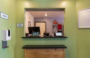 einen Spiegel in einem Zimmer mit einer Theke mit Laptops in der Unterkunft Extended Stay America Select Suites - Pensacola - Northeast in Pensacola