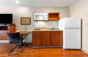 una cucina con frigorifero bianco, tavolo e scrivania di Extended Stay America Select Suites - Oklahoma City - West a Oklahoma City