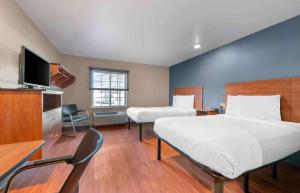 um quarto de hotel com duas camas e uma televisão em Extended Stay America Select Suites - Oklahoma City - West em Oklahoma City