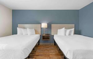 Duas camas num quarto com paredes azuis em Extended Stay America Select Suites - Orlando - Airport em Orlando