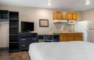 a small kitchen with a bed and a refrigerator at Extended Stay America Select Suites - Orlando - South in Orlando