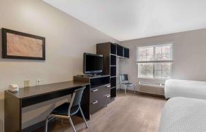 1 dormitorio con escritorio, ordenador y cama en Extended Stay America Select Suites - Orlando - South en Orlando