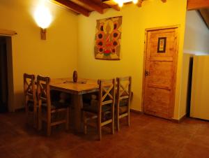 a dining room with a wooden table and chairs at La Posada de Buda in Malargüe