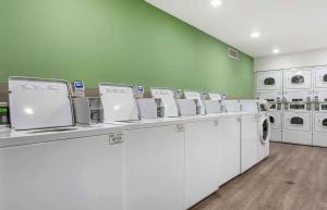 una lavandería con lavadoras blancas y una pared verde en Extended Stay America Suites - Portland - East, en Portland