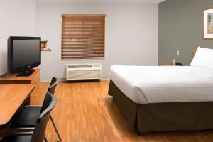 een slaapkamer met een bed en een bureau met een computer bij Extended Stay America Select Suites - Provo - American Fork in Lehi