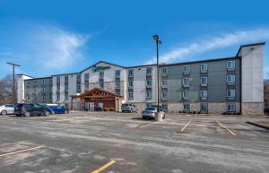 un gran edificio con coches estacionados en un estacionamiento en Extended Stay America Select Suites - Pittsburgh - Cranberry, en Unionville