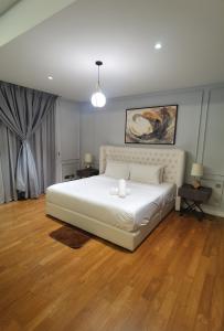 - une chambre avec un grand lit blanc et du parquet dans l'établissement Anggun Residence KL Malaysia, à Kuala Lumpur