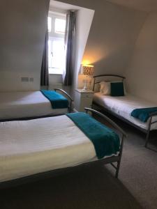 um quarto de hotel com duas camas e uma janela em The Angerstein Hotel em Londres