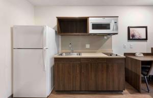 uma cozinha com um frigorífico branco e um lavatório em Extended Stay America Suites - Redlands em Redlands