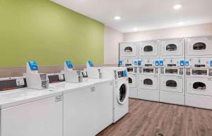a laundry room with white washing machines and green walls at Extended Stay America Suites - Redlands in Redlands