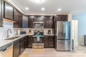 cocina con armarios de madera y nevera de acero inoxidable en Apartment at Vista Cay Resort, en Orlando