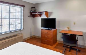 a bedroom with a desk with a television and a deskictericter at Extended Stay America Select Suites - Wichita - North in Wichita