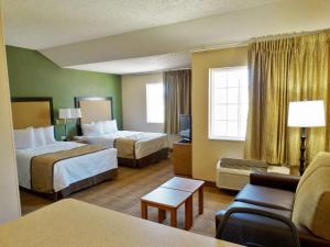 Extended Stay America Suites - Charleston - Airport في تشارلستون: غرفة فندقية بسريرين واريكة