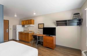 eine kleine Küche mit einem Schreibtisch und einem Kühlschrank in der Unterkunft Extended Stay America Select Suites - Firestone in Firestone