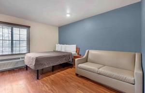 uma sala de estar com um sofá e uma mesa em Extended Stay America Select Suites - Shreveport - Airport em Shreveport