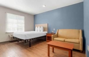 1 dormitorio con 1 cama y 1 sofá en Extended Stay America Select Suites - Tallahassee - Northwest, en Tallahassee