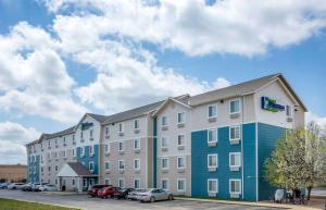 Extended Stay America Select Suites - Springfield - South - Battlefield في سبرينغفيلد: مبنى كبير به سيارات تقف في موقف للسيارات