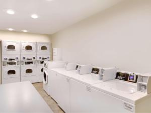 - une buanderie blanche avec lave-linge et sèche-linge blancs dans l'établissement Extended Stay America Select Suites - Shreveport - Bossier City, à Bossier City