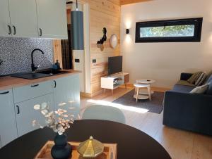 eine Küche und ein Wohnzimmer mit einem Tisch in der Unterkunft Jardín Las Secuoyas in Becerril de la Sierra