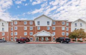 a large building with a red truck parked in front of it at Extended Stay America Select Suites - Oklahoma City - Norman in Norman