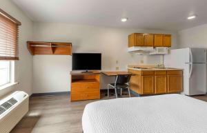 Cette chambre comprend une cuisine équipée d'un bureau et d'un réfrigérateur. dans l'établissement Extended Stay America Select Suites - Oklahoma City - Norman, à Norman