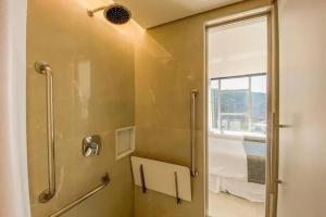 a bathroom with a shower with a mirror and a window at Hotel Nacional in Rio de Janeiro