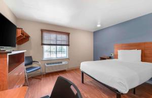 Del CityにあるExtended Stay America Select Suites - Oklahoma City - Del Cityのベッドルーム(大型ベッド1台、テレビ付)