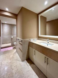 a bathroom with a sink and a mirror and a tub at SunShine AbuTig Marina in Hurghada