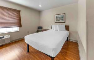 um quarto com uma cama branca e uma janela em Extended Stay America Select Suites - Oklahoma City - Southeast em Moore