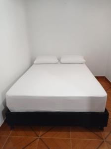 łóżko w pokoju z białym materacem w obiekcie Casa flora w mieście Circasia