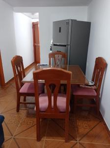 kuchnia ze stołem, krzesłami i lodówką w obiekcie Casa flora w mieście Circasia