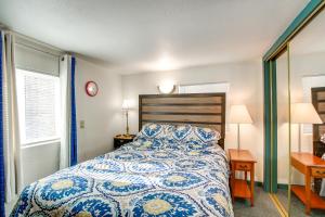 a bedroom with a blue and white bed and two windows at Colorful Cottage with Hot Tub - Steps to Long Lake! in Campbellsport